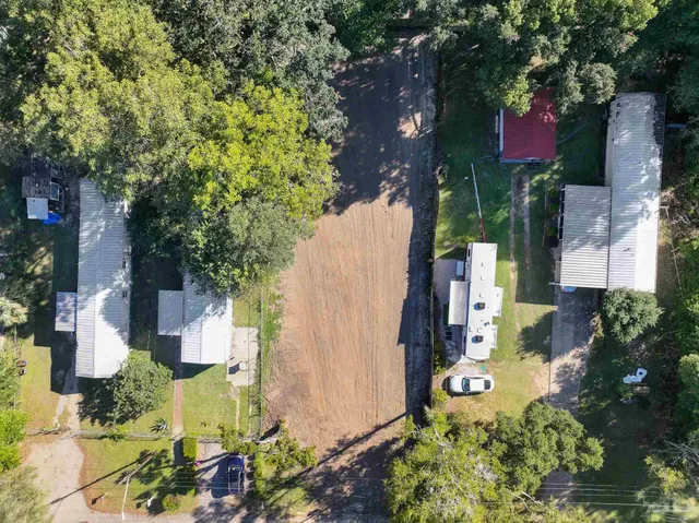 an aerial view of residential house with outdoor space and trees all around