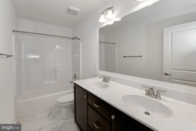 a bathroom with a sink double vanity granite tub and a mirror