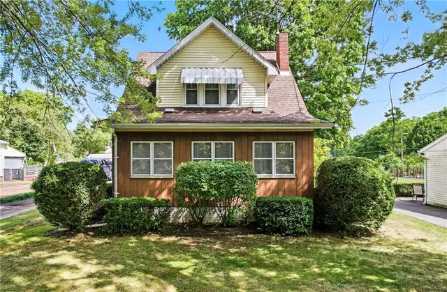 a front view of a house with a yard and potted plants