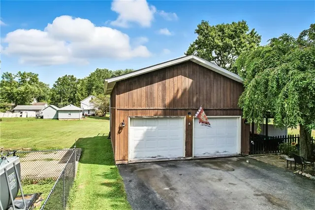 a view of backyard of house with green space and porch area