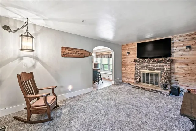 a living room with furniture a flat screen tv and a fireplace