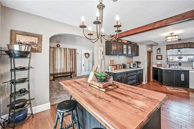 a kitchen with stainless steel appliances granite countertop a sink dishwasher and a refrigerator with wooden floor