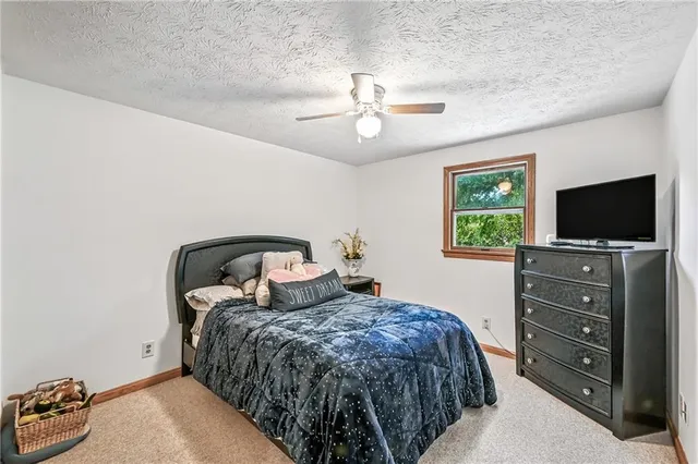 a bedroom with a bed and a flat tv screen on dresser