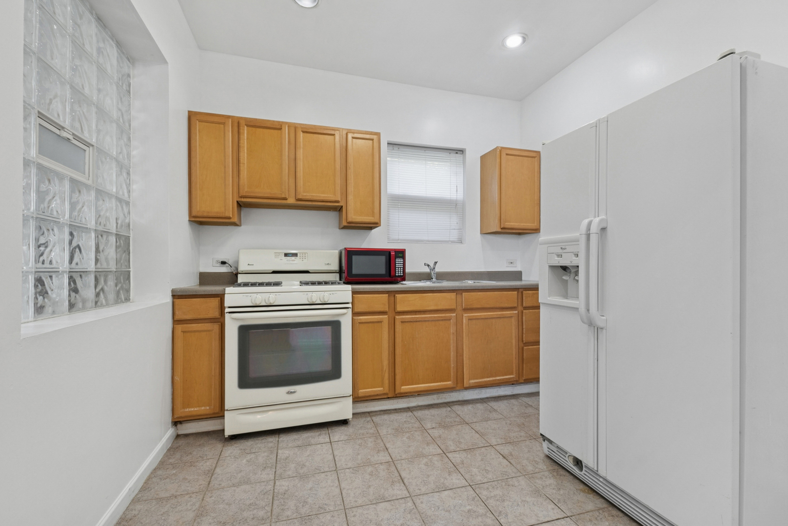 8040 South May Street Chicago, IL 60620 - Photo 11 of 23 a kitchen with a stove top oven sink and cabinets