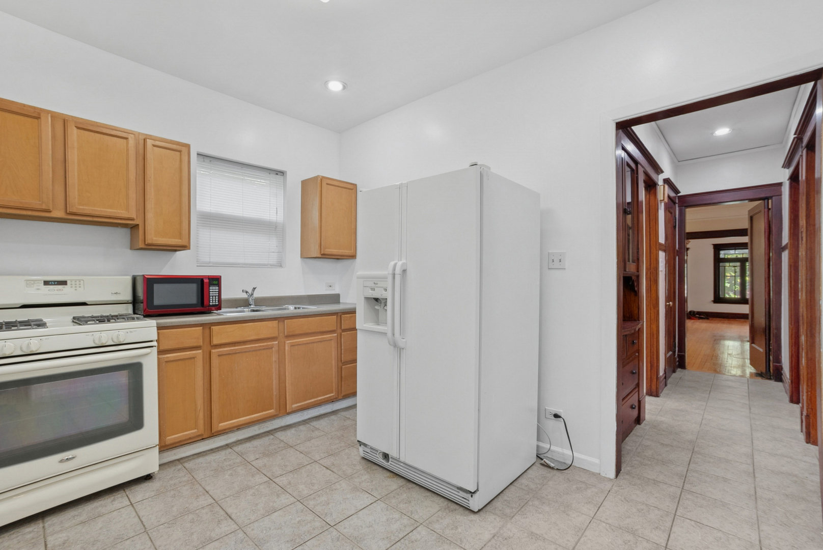 8040 South May Street Chicago, IL 60620 - Photo 12 of 23 a kitchen with white cabinets and white appliances