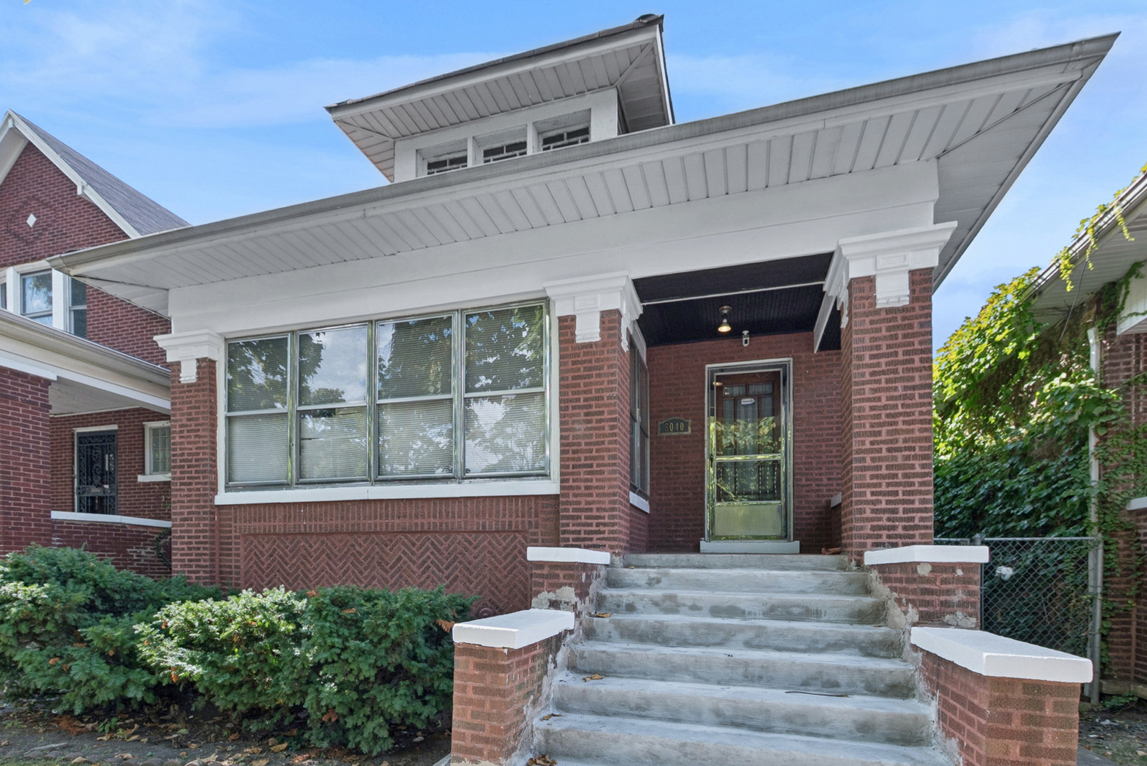8040 South May Street Chicago, IL 60620 - Photo 2 of 23 a front view of a house with a garden