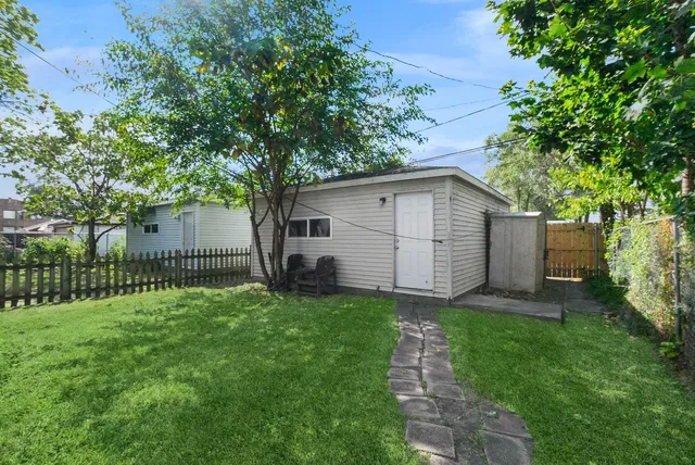 a white house that has tree in front of it