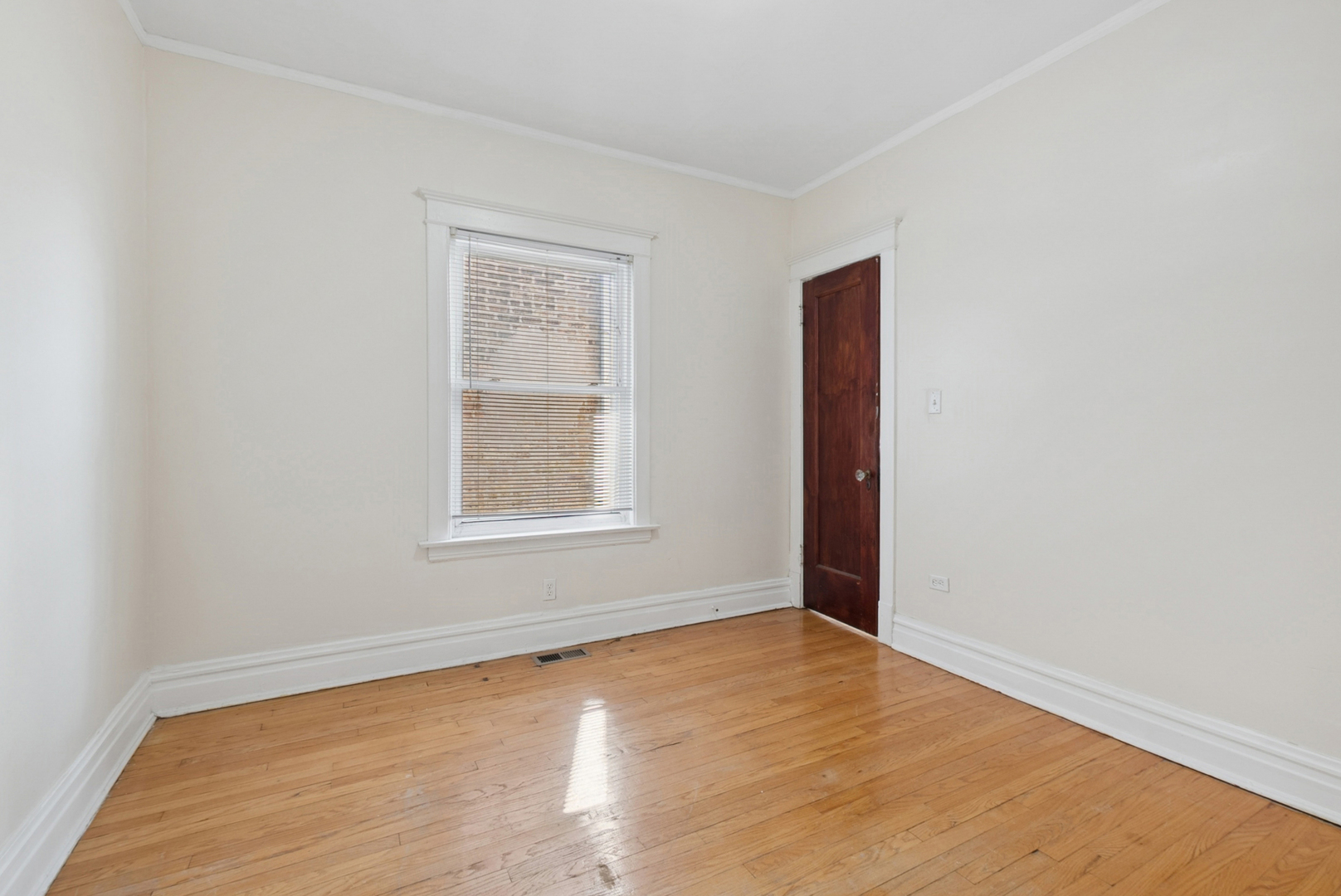 8040 South May Street Chicago, IL 60620 - Photo 9 of 23 an empty room with wooden floor and windows