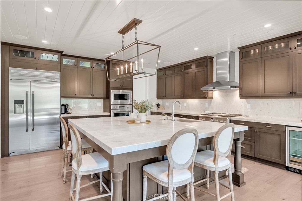 12237 Cortona Place Riverside, CA 92503 - Photo 4 of 17 a kitchen with kitchen island granite countertop a table chairs refrigerator and microwave