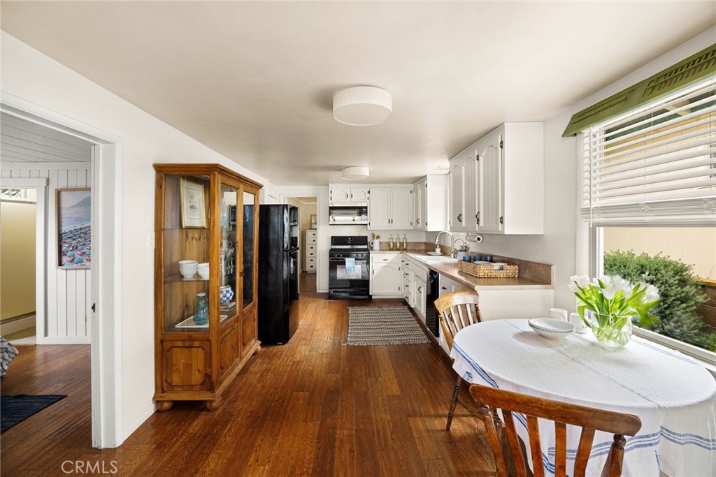 3448 Studio Drive Cayucos, CA 93430 - Photo 15 of 47 a kitchen with stainless steel appliances granite countertop a refrigerator a stove top oven a sink dishwasher and white cabinets with wooden floor