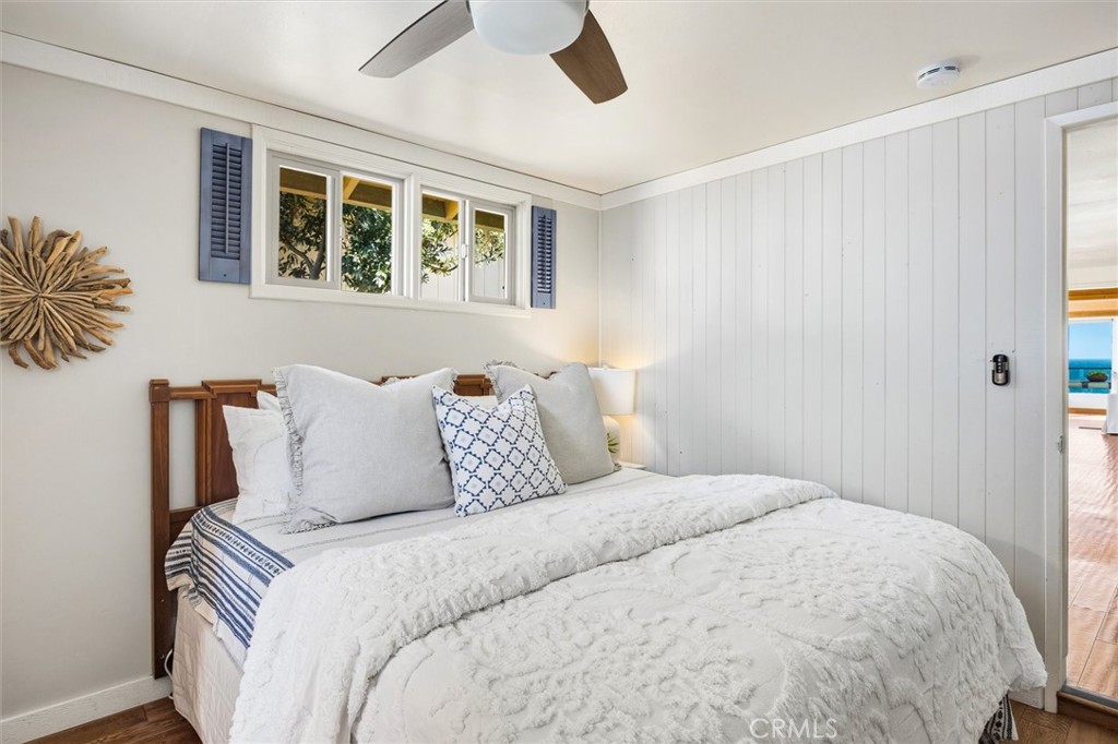 3448 Studio Drive Cayucos, CA 93430 - Photo 24 of 47 a large bed sitting in a bedroom next to a window and a chandelier fan