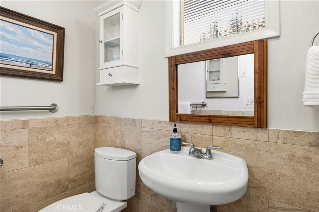 3448 Studio Drive Cayucos, CA 93430 - Photo 25 of 47 a bathroom with a toilet sink and mirror
