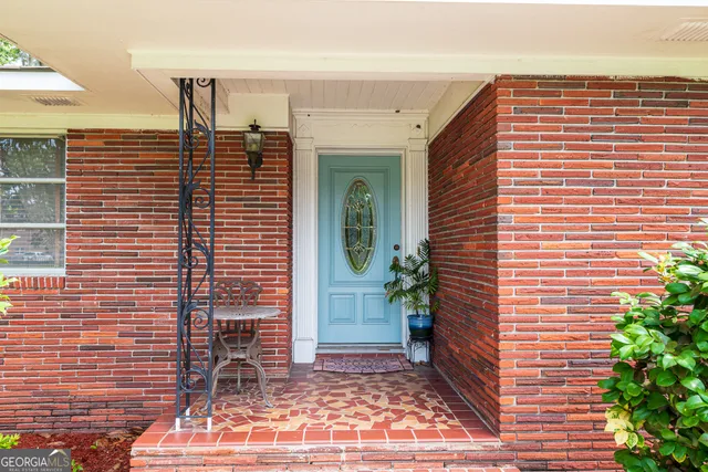 a view of a house with backyard and a tree