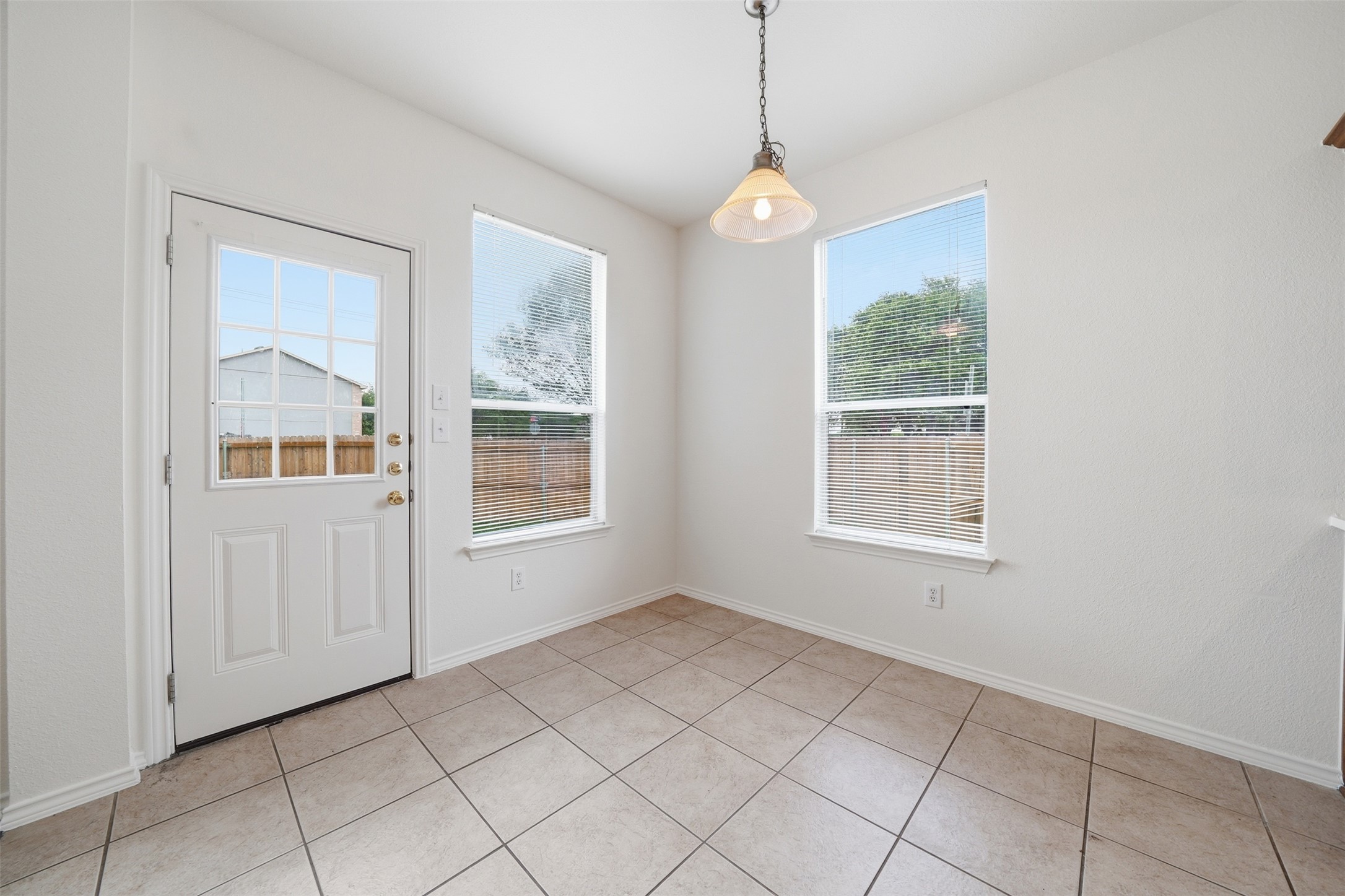 118 Invierno Street Kyle, TX 78640 - Photo 4 of 37 A well-lit breakfast area with durable tile flooring and a view of the private yard.