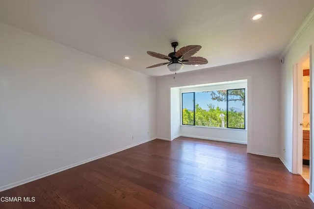 a view of room with window ceiling fan and hardwood floor