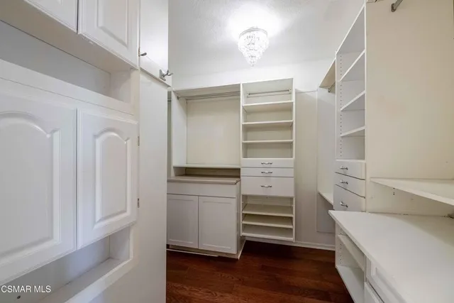 a view of walk in closet with empty racks