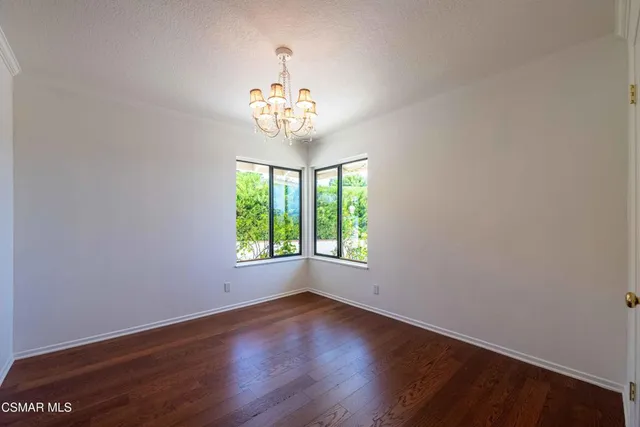 an empty room with wooden floor and a window