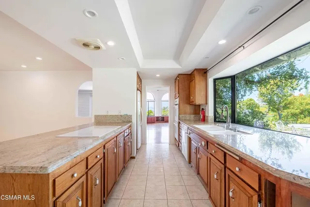 a large kitchen with stainless steel appliances granite countertop plenty of counter top and wooden floor