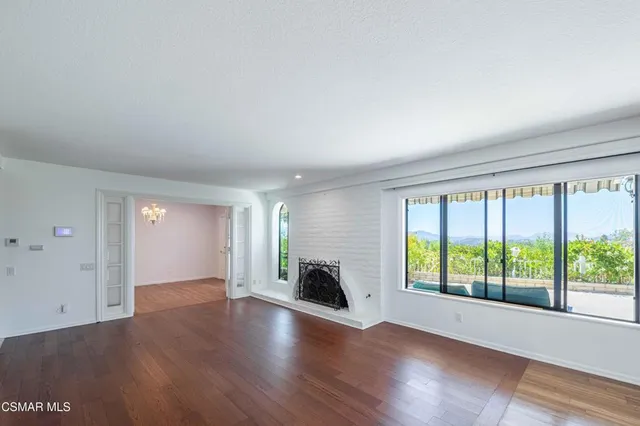 an empty room with wooden floor and a fireplace