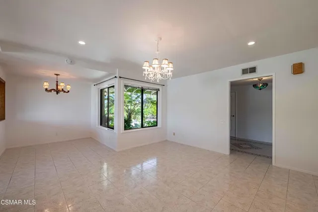 an empty room with windows and chandelier