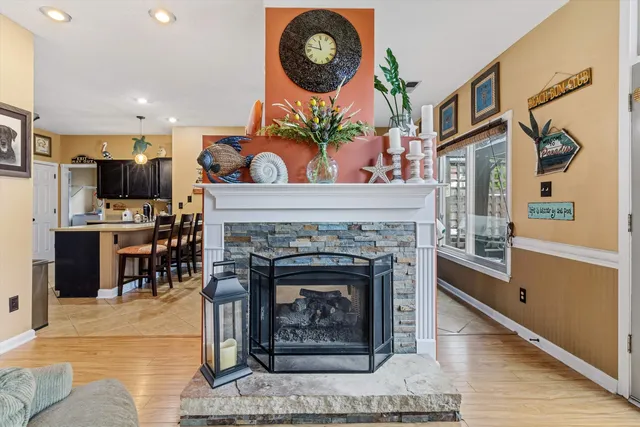 a living room with furniture a fireplace and kitchen view