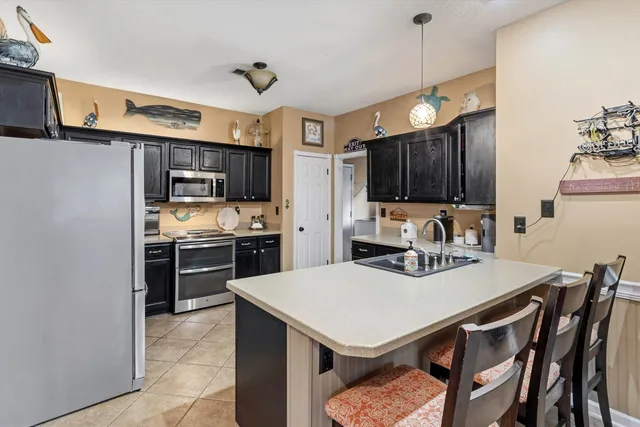 a kitchen with a sink a stove and chairs