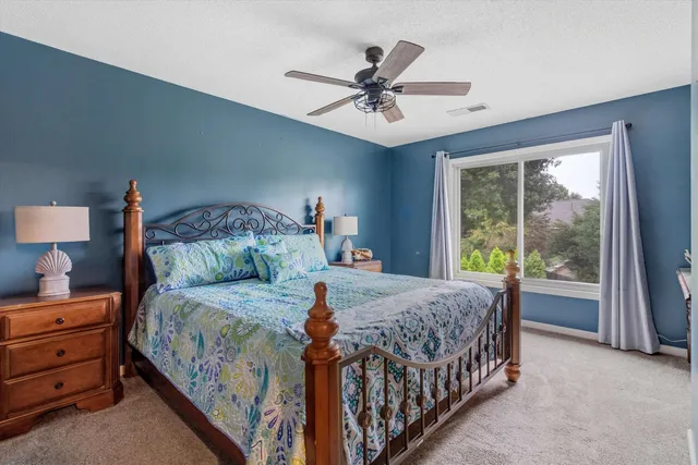 a bedroom with a bed a chandelier and dresser