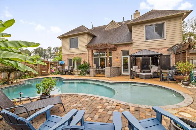 a view of a house with swimming pool and sitting area