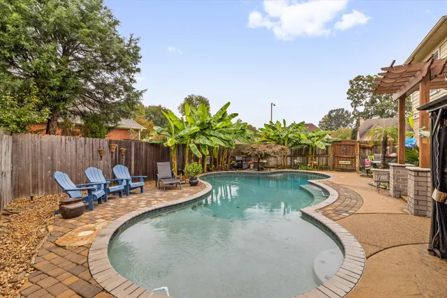 a view of swimming pool with outdoor seating and plants