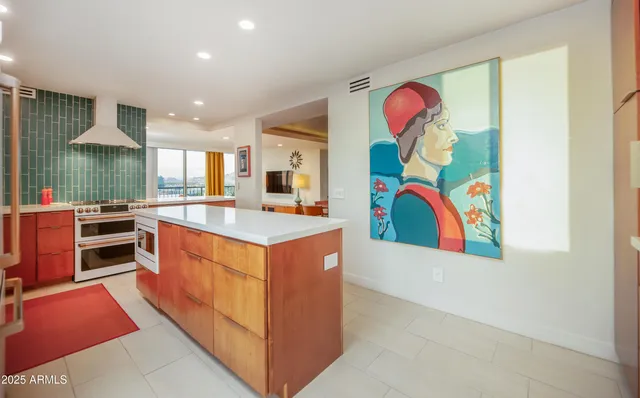 a dining hall with stainless steel appliances kitchen island granite countertop a table and chairs