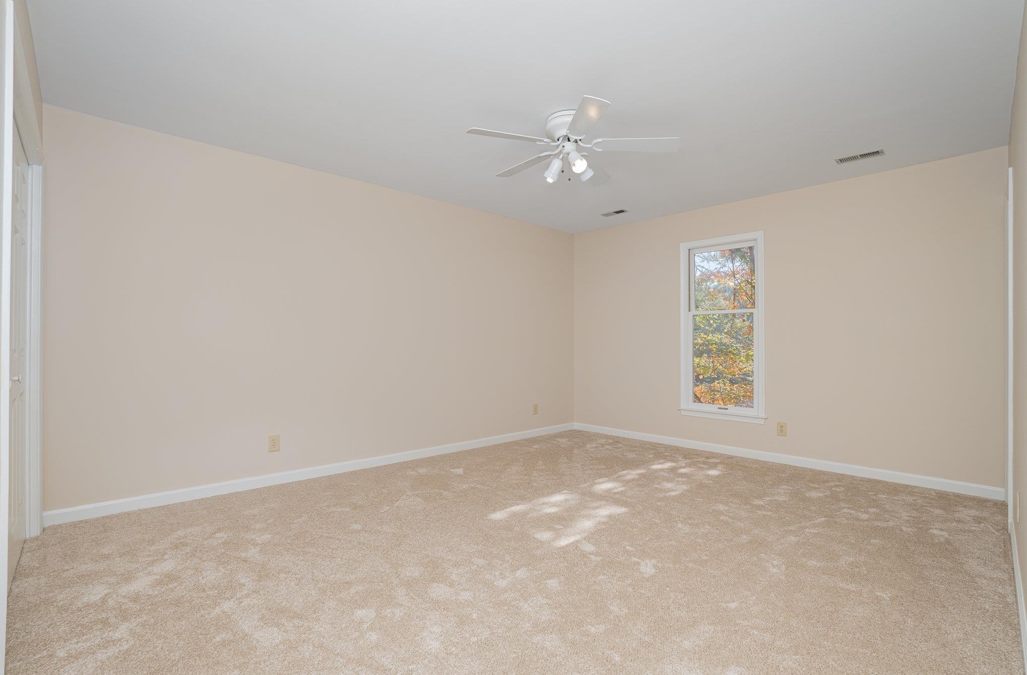 4110 Olde Coach Road Durham, NC 27707 - Photo 19 of 27 an empty room with a window and ceiling fan