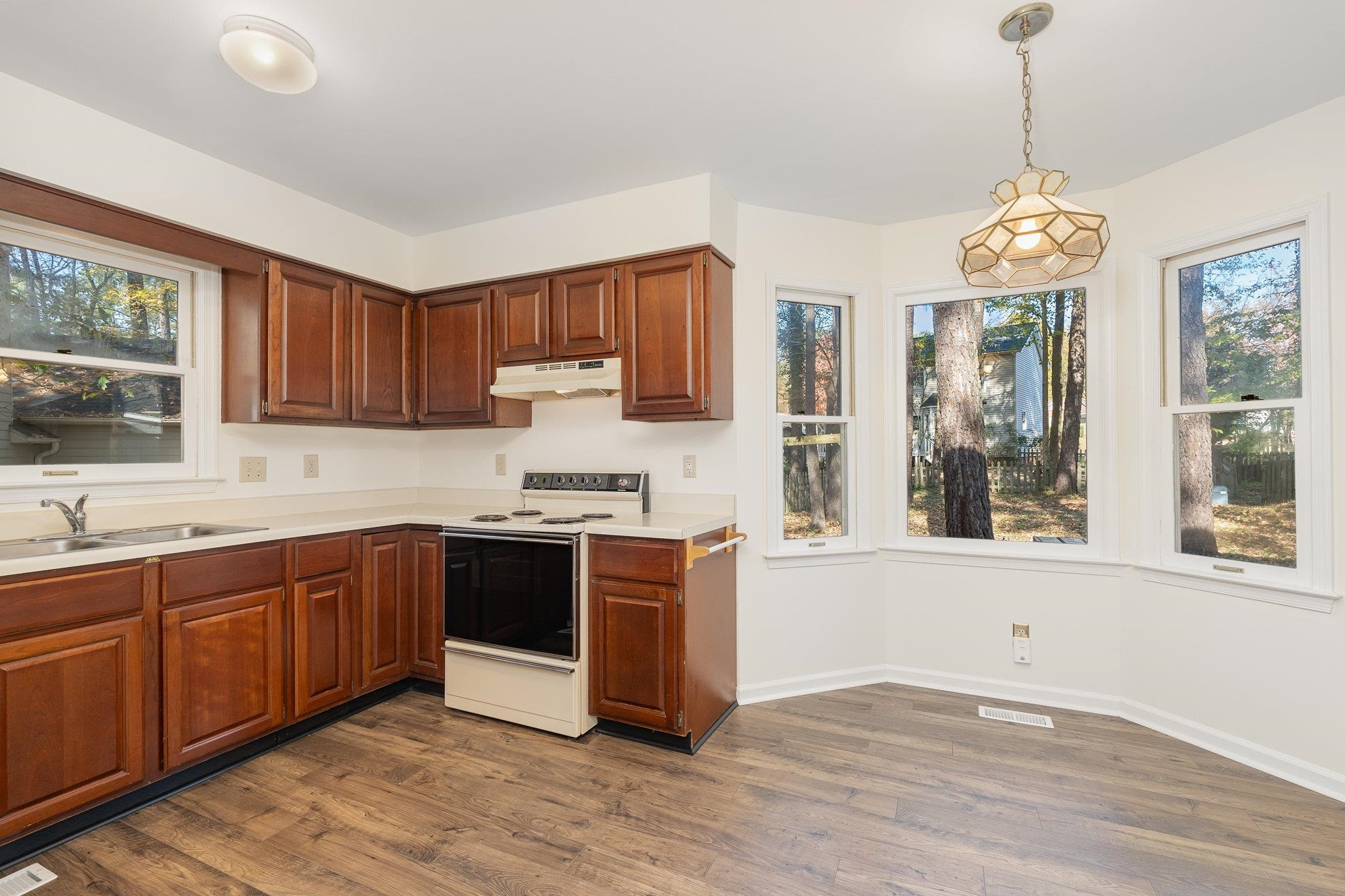 4110 Olde Coach Road Durham, NC 27707 - Photo 8 of 27 a large kitchen with stainless steel appliances granite countertop a stove a sink dishwasher and a microwave oven with wooden floor