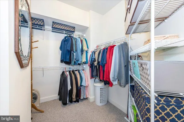 a view of walk in closet with clothes and shoes