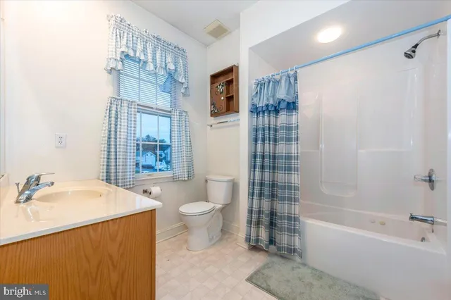 a bathroom with a bathtub toilet sink vanity and windows