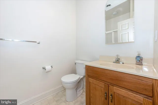 a bathroom with a granite countertop toilet sink and mirror