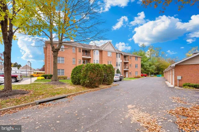 a view of a house with a yard and large tree