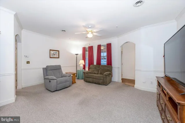 a living room with furniture and a ceiling fan