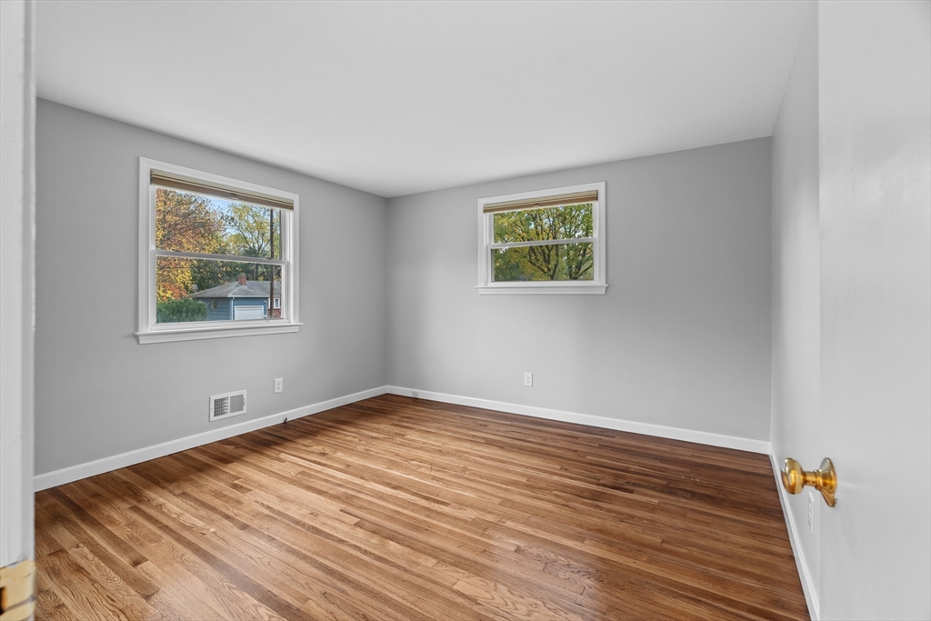 5 Janice Circle Framingham, MA 01701 - Photo 13 of 36 a view of an empty room with wooden floor and a window