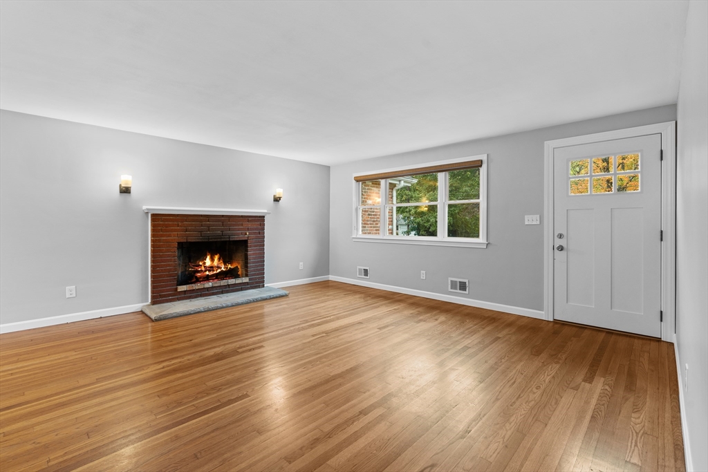 5 Janice Circle Framingham, MA 01701 - Photo 6 of 36 an empty room with wooden floor a fireplace and windows