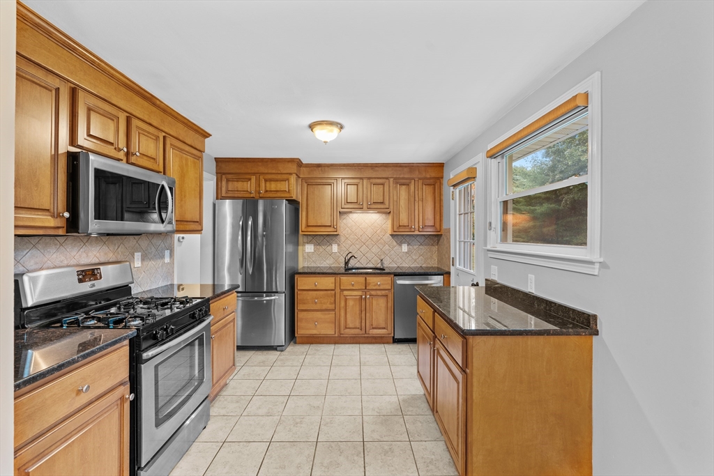 5 Janice Circle Framingham, MA 01701 - Photo 8 of 36 a kitchen with stainless steel appliances granite countertop a stove top oven microwave and refrigerator