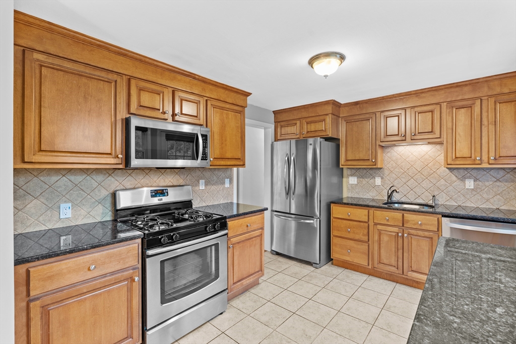 5 Janice Circle Framingham, MA 01701 - Photo 9 of 36 a kitchen with granite countertop a refrigerator stove top oven and sink