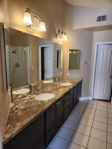 a bathroom with a granite countertop sink a mirror and a shower