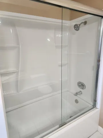 a bathroom with a shower and a bath tub