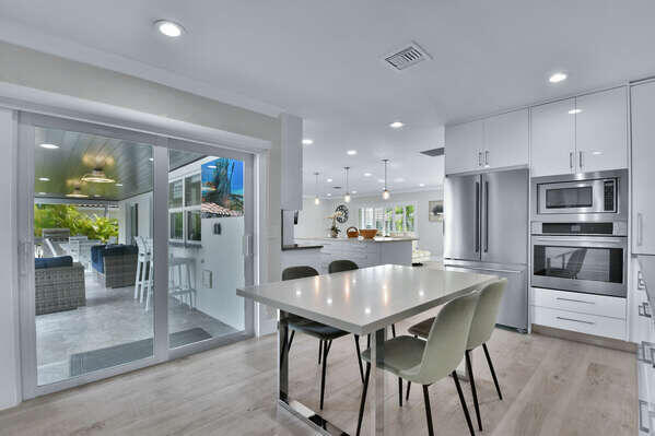 839 Enfield Street Boca Raton, FL 33487 - Photo 6 of 36 a kitchen with a dining table chairs and refrigerator