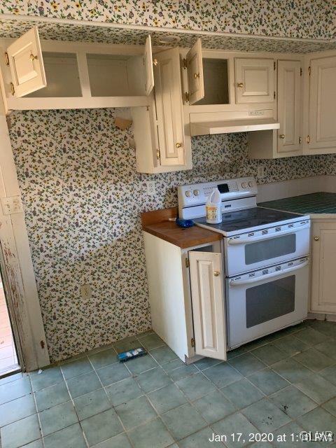 611 Fairgrounds Road Gilbert, PA 18331 - Photo 4 of 10 a kitchen with white cabinets and a stove