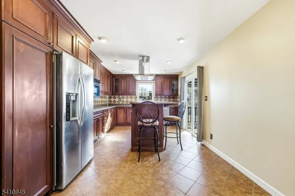 a kitchen with stainless steel appliances granite countertop a refrigerator and a sink