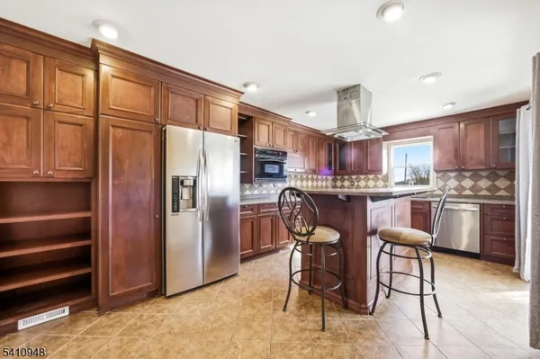 a kitchen with stainless steel appliances granite countertop a refrigerator and a stove top oven