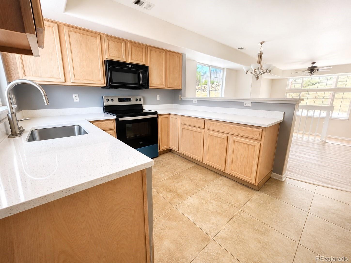 8199 Welby Road, Unit 4301 Denver, CO 80229 - Photo 8 of 19 a kitchen with stainless steel appliances granite countertop a sink a stove top oven a counter space and cabinets