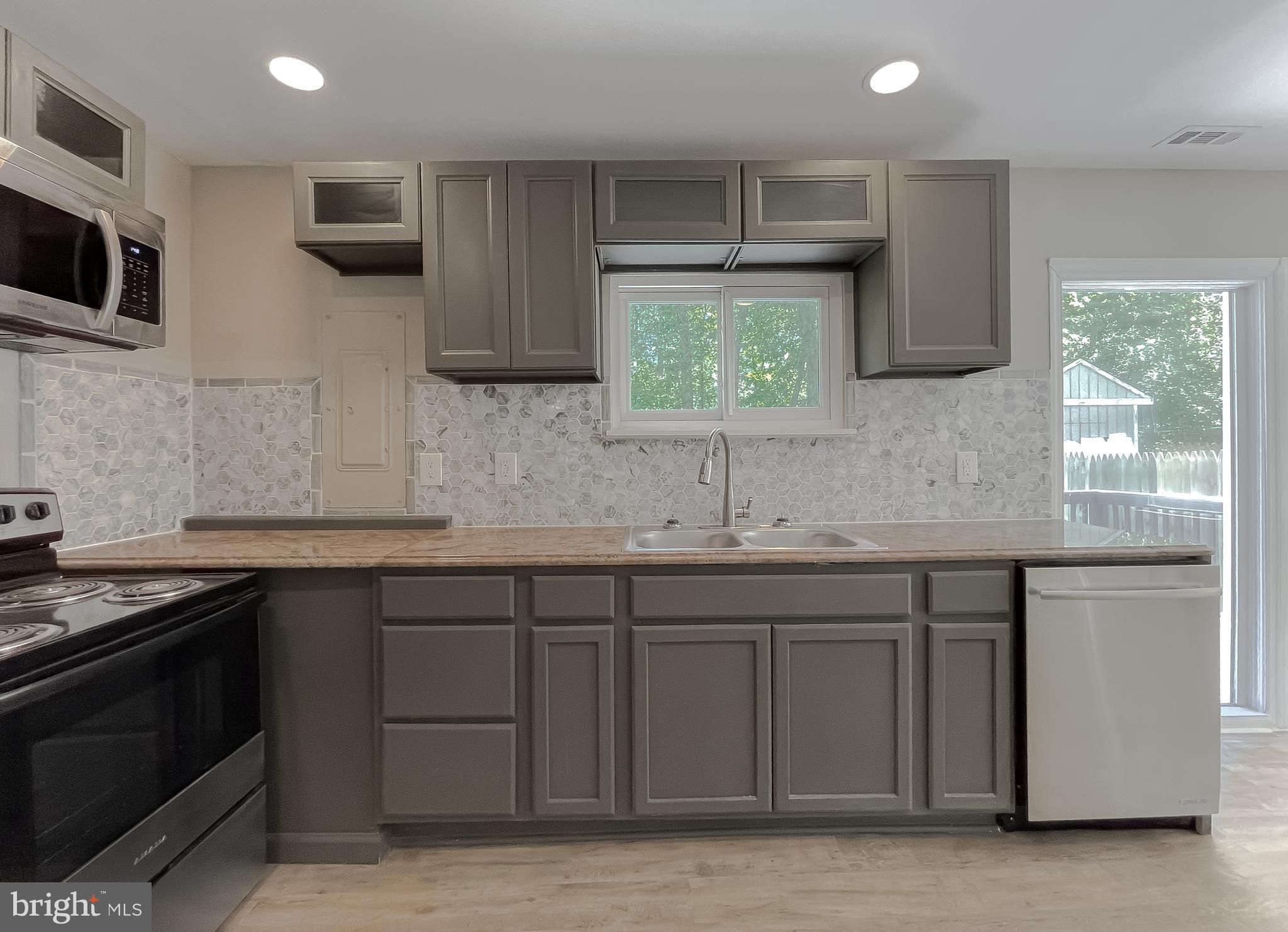 1607 Beech Road St. Leonard, MD 20685 - Photo 13 of 33 a kitchen with stainless steel appliances granite countertop a sink stove and microwave