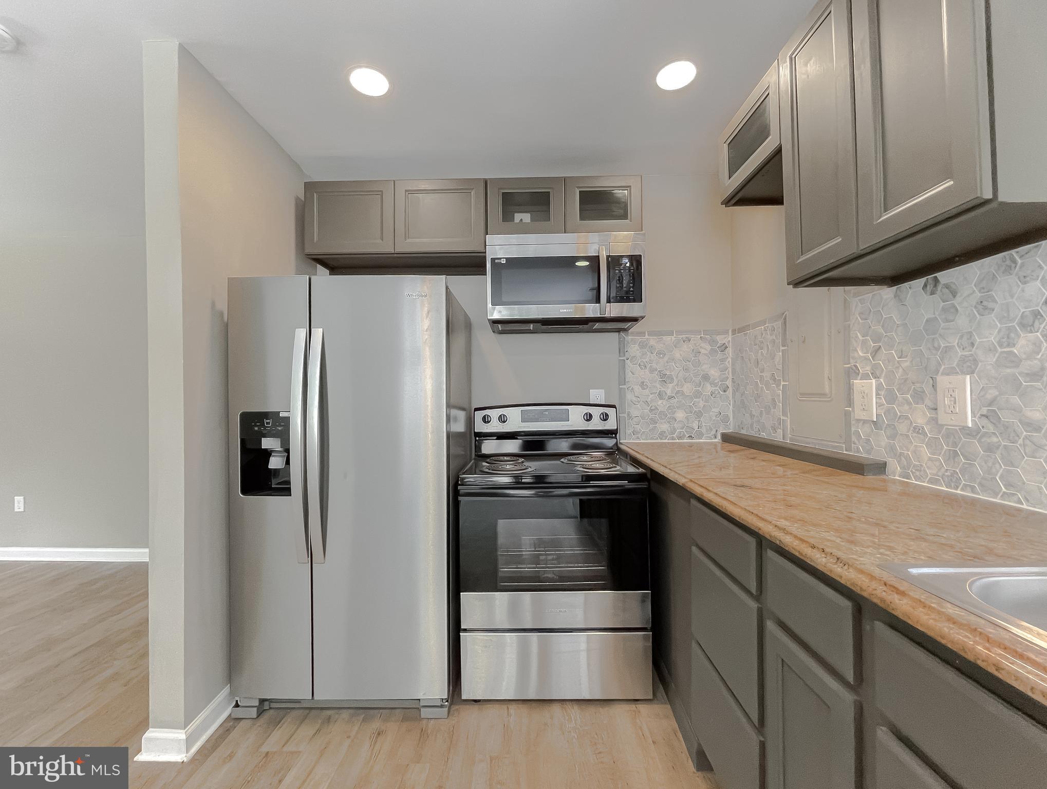 1607 Beech Road St. Leonard, MD 20685 - Photo 14 of 33 a kitchen with stainless steel appliances granite countertop a refrigerator and a sink